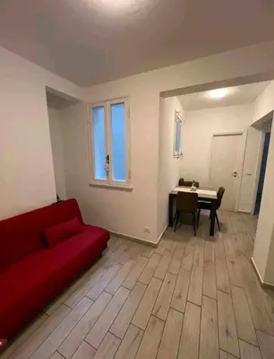 a living room with a red couch and a table at Bignami street in Rome