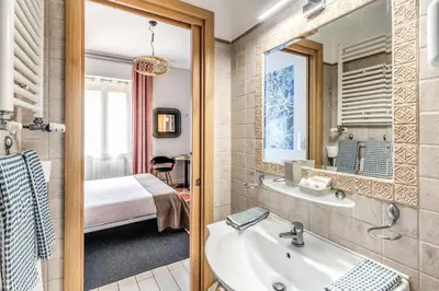 a bathroom with a sink and a mirror and a bed at Otranto 36 in Rome