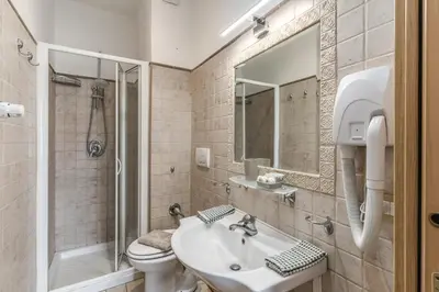 a bathroom with a sink and a toilet and a mirror at Otranto 36 in Rome