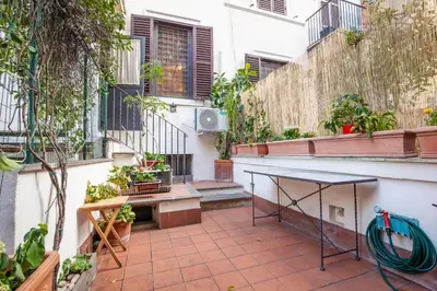 a patio with a table and some plants at Il giardino di Bobo in Rome