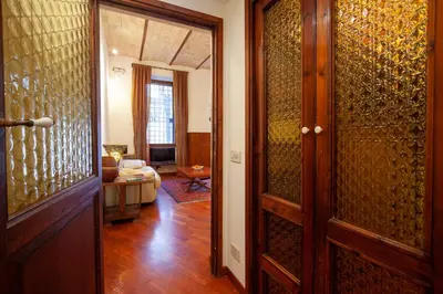 a hallway with a door and a living room at Il giardino di Bobo in Rome