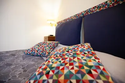 a bedroom with a bed with colorful pillows on it at Il giardino di Bobo in Rome