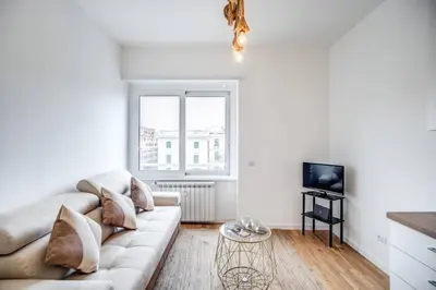 a white living room with a couch and a tv at Naos Suite close Popolo Square in Rome