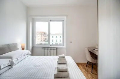 a white bedroom with a bed and a desk at Naos Suite close Popolo Square in Rome