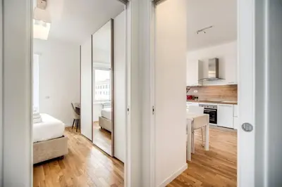 a white apartment with a bedroom and a kitchen at Naos Suite close Popolo Square in Rome