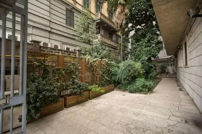 a courtyard with plants in pots on a building at Naos Suite close Popolo Square in Rome