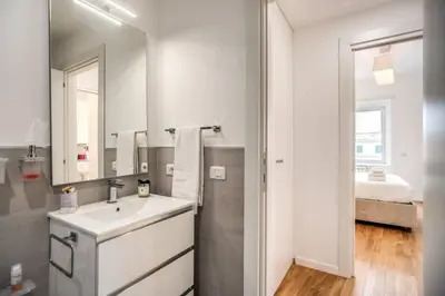 a white bathroom with a sink and a mirror at Naos Suite close Popolo Square in Rome
