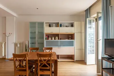 a dining room with a table and chairs and a television at GuestHost - Sunny Apartment Piramide in Rome