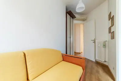 a yellow couch in a room with a hallway at GuestHost - Sunny Apartment Piramide in Rome