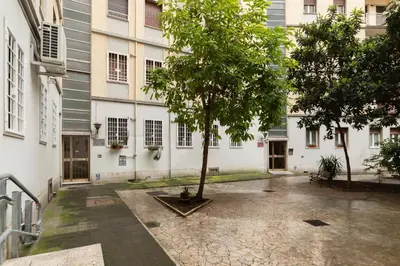 a courtyard with a tree in the middle of a building at GuestHost - Sunny Apartment Piramide in Rome