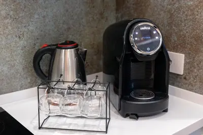 a coffee maker and glasses on a counter next to a toaster at Barcaccia Exclusive apartment in Rome