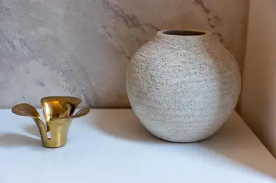 a white vase and a gold object on a table at Barcaccia Exclusive apartment in Rome