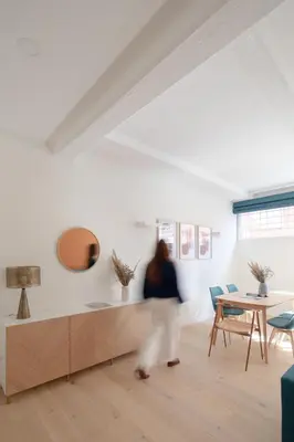 a woman walking through a living room with a table and chairs at Noah Charme in Rome