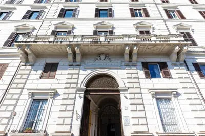 a large white building with a balcony over the door at Elegantia Luxury Rooms in Rome