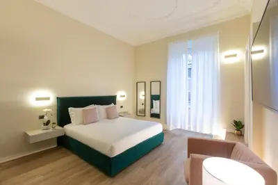 a bedroom with a bed and a chair in a room at Elegantia Luxury Rooms in Rome