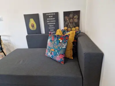 a gray couch with two pillows on top of it at Home K&Y Elite Pineta in Rome