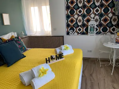 a bedroom with a yellow bed with towels on it at Home K&Y Elite Pineta in Rome