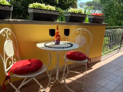 two chairs and a table with two glasses of wine at Home K&Y Elite Pineta in Rome