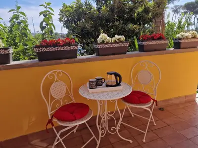 a table and two chairs with a tea kettle on it at Home K&Y Elite Pineta in Rome