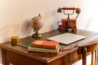 a desk with a laptop and a clock and a phone at Appartamento via di San Martino ai Monti in Rome