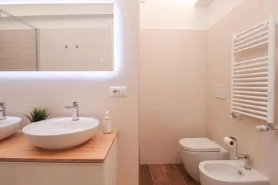 a white bathroom with a sink and a toilet at Ziani 5 Rome Vatican Apartment in Rome