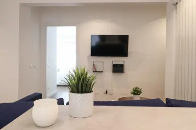 a living room with a table and a tv on a wall at Ziani 5 Rome Vatican Apartment in Rome