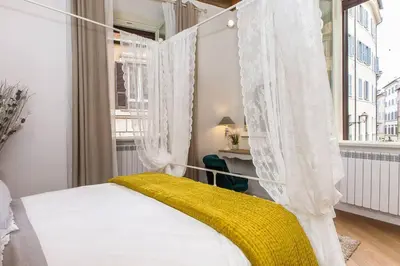 a bedroom with a canopy bed with a yellow blanket at Navona Atmosphere A few meters from Piazza Navona !! in Rome