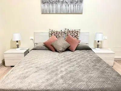 a large bed with two night stands and two lamps at suite magenta in Rome
