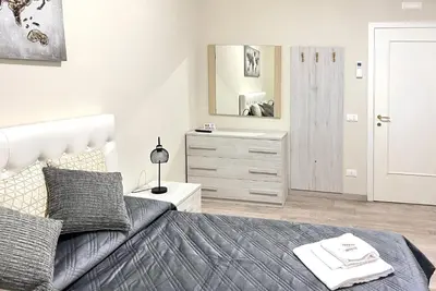a bedroom with a bed and a dresser with a mirror at suite magenta in Rome
