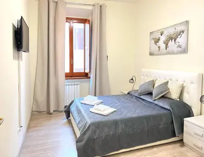a bedroom with a bed and a window and a television at suite magenta in Rome
