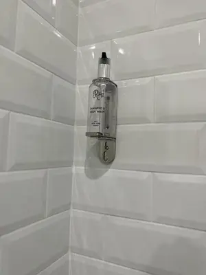a bottle of soap sitting on the wall of a shower at IL NINFEO San Giovanni ROMA in Rome
