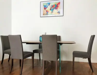 a dining room table and chairs with a painting on the wall at Eternal City Apartment in Rome