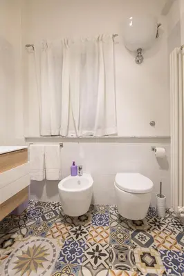 a white bathroom with a toilet and a sink at Sofia’s home in Rome