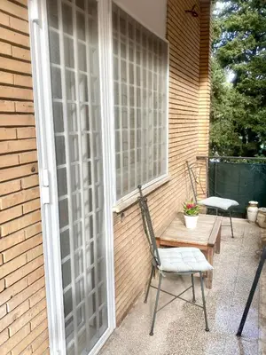 a patio with two chairs and a table and a window at Sofia’s home in Rome