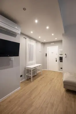 a living room with a bench and a flat screen tv at Sofia’s home in Rome