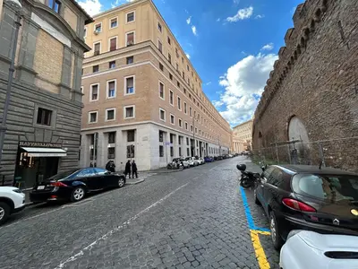 a street with cars parked on the side of a building at Raffaello's Place in Rome