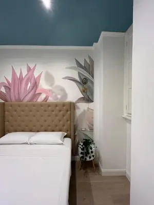 a bedroom with a bed with a flower painting on the wall at Raffaello's Place in Rome