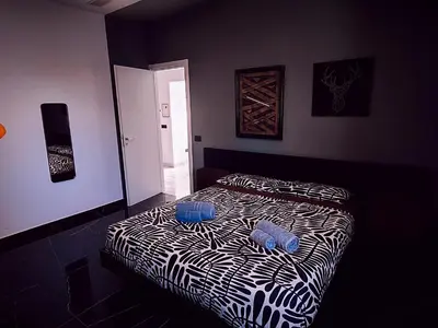 a bedroom with a bed with two blue pillows on it at Il quattro e l'otto in Rome