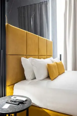 a bed with two yellow pillows and a table at Home at Rome Luxury Navona Guesthouse in Rome