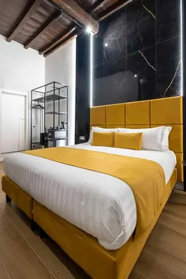 a bedroom with a large bed with a yellow blanket at Home at Rome Luxury Navona Guesthouse in Rome