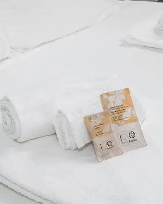 a white towel and a box on a bed at Suites Campo de' Fiori - Zen18-19-20 in Rome
