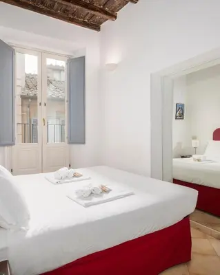 a bedroom with two beds and a window at Suites Campo de' Fiori - Zen18-19-20 in Rome