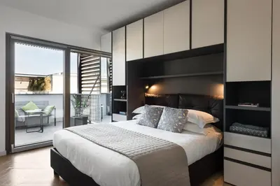 a bedroom with a large bed and a balcony at Idyllia - Lumina rooftop penthouse in Trastevere in Rome
