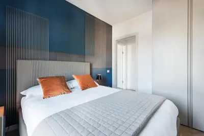 a bedroom with a large white bed with two orange pillows at Idyllia - Lumina rooftop penthouse in Trastevere in Rome