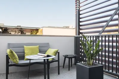 a balcony with a bench and a table and a plant at Idyllia - Lumina rooftop penthouse in Trastevere in Rome