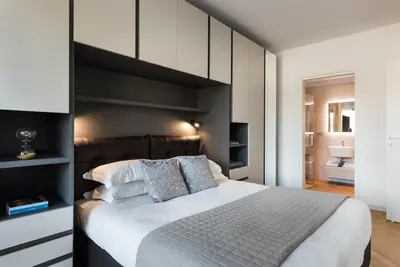 a bedroom with a large bed with a black headboard at Idyllia - Lumina rooftop penthouse in Trastevere in Rome