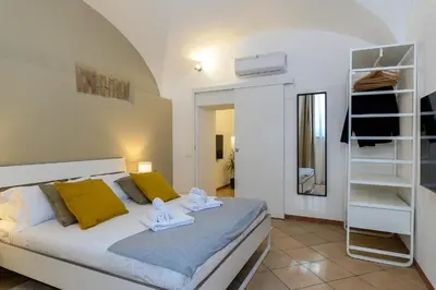 a bedroom with a bed with yellow pillows and a mirror at Cozy & Central with Private Entrance by NDP rent in Rome