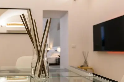a glass vase with sticks in it on a glass table at Cozy & Central with Private Entrance by NDP rent in Rome