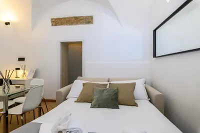 a bedroom with a white bed and a table at Cozy & Central with Private Entrance by NDP rent in Rome