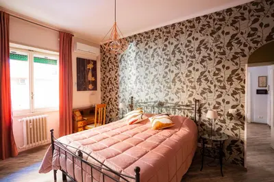 a bedroom with a bed with a pink comforter at DOMUS PETRI- CASA A S. PIETRO in Rome